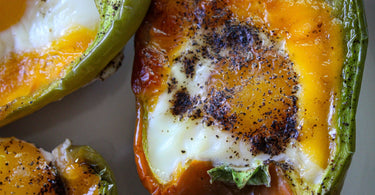 Half green pepper filled with egg and cheese, roasted and seasoned with black pepper.